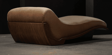 A modern chaise lounge featuring a distinctive ergonomic S-curve design. It consists of a plush, upholstered top in a brown, velvety fabric, supported by a sculptural wooden frame and base. The wood exhibits a dark, rich tone with a polished finish, highlighting its natural grain and elegant, flowing lines. The design emphasizes comfort and aesthetic form, suggesting a luxurious and contemporary piece. — 3D model