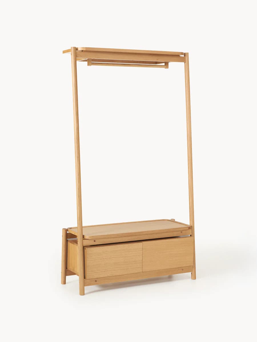 A minimalist open wardrobe unit constructed from light-toned solid wood, featuring a tall, angled A-frame design. The upper section includes a flat top shelf and an integrated hanging rail for clothes. The lower section incorporates a chest with two wide, flush-front drawers, topped by an additional flat surface, likely for display or additional storage. The overall aesthetic is clean, functional, and contemporary. — 3D model