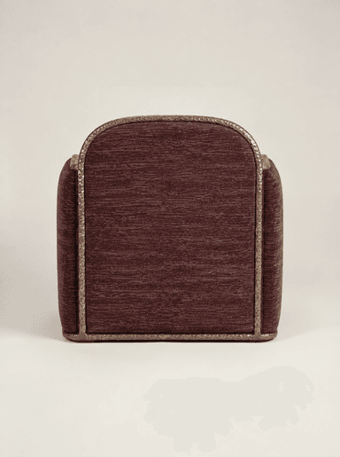A contemporary upholstered armchair featuring a deep plum or burgundy textured fabric. It is characterized by a unique, decorative hammered metal frame that outlines the oval backrest, armrests, and base, providing a distinct stylistic element and material contrast. The seat cushion is integrated, presenting a substantial and refined form. — 3D model