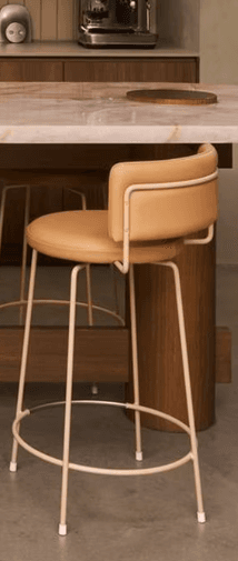 A contemporary bar stool with a mid-century modern aesthetic, featuring an olive green upholstered seat and backrest, supported by a slender black metal frame with a brass footrest accent. — 3D model