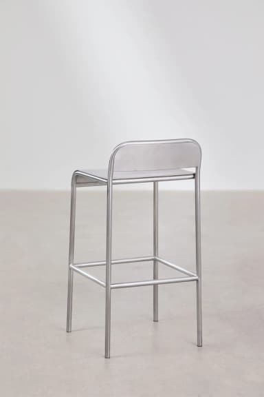 A minimalist industrial bar stool constructed entirely from brushed metal, likely stainless steel or aluminum. It features a tubular frame, a rectangular footrest, and an integrated seat and low backrest with rounded edges. — 3D model