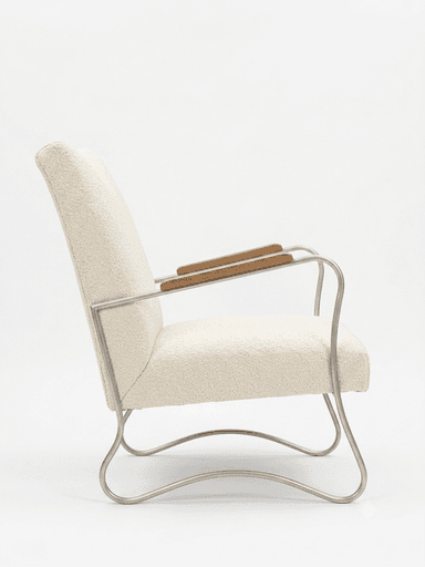 A contemporary armchair featuring an off-white bouclé upholstery on the seat and backrest, supported by a bent tubular metal frame. The armrests have wooden caps. The frame forms a continuous, sled-like base. — 3D model