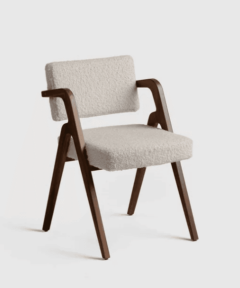 A modern armchair featuring a dark wooden frame with gracefully curved armrests and angled legs, complemented by light-toned, textured bouclé upholstery on the seat and backrest. — 3D model
