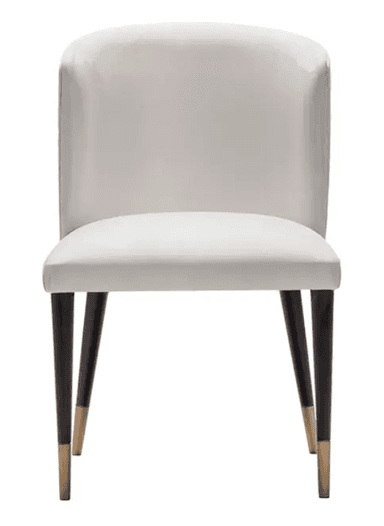 A contemporary white upholstered chair featuring a curved backrest with a distinctive hexagonal quilted pattern on its outer surface. The seat and inner back are smoothly upholstered in white. It stands on four slender, tapered dark legs, each finished with a brass-colored ferrule. — 3D model