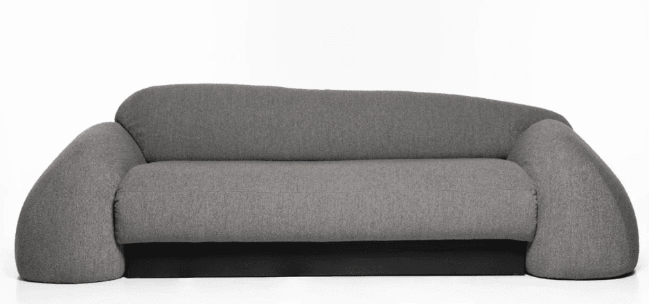 A contemporary sofa with a rounded, organic silhouette. It features a thick, plush seat and backrest upholstered in a textured gray fabric. The armrests are uniquely shaped, widening and curving outwards at the ends, creating a distinctive, sculptural form. The base of the sofa is a solid, dark-colored rectangular block, providing a contrasting foundation to the soft upholstery. — 3D model