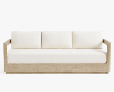 A three-seater sofa with a light wood frame and off-white cushions. The frame has a clean, minimalist design with straight lines. The seat and back cushions appear to be upholstered in a fabric. — 3D model
