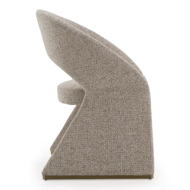 A contemporary, fully upholstered accent chair featuring a distinctive sculptural form. The backrest curves continuously, seamlessly integrating with the solid, geometric base. It is covered in a textured, light beige fabric, and subtle brass accents are visible at the bottom of the base. — 3D model