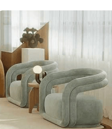 A modern armchair with a rounded, sculptural design. The armchair features a thick, tubular frame that forms the arms and backrest, which appears to be upholstered in a soft, plush fabric. The seat is wide and cushioned, providing a comfortable seating surface. The overall aesthetic is contemporary and inviting. — 3D model
