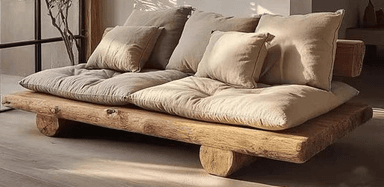 A rustic daybed featuring a natural wood frame made from thick, unfinished logs or planks, supporting thick, light-colored fabric cushions and several throw pillows. — 3D model