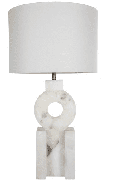 A modern table lamp featuring a sculptural, geometric base crafted from white onyx with subtle brown veining, topped by a classic white drum shade. The base consists of rectangular blocks supporting a central ring shape with a void, creating an abstract, architectural aesthetic. — 3D model