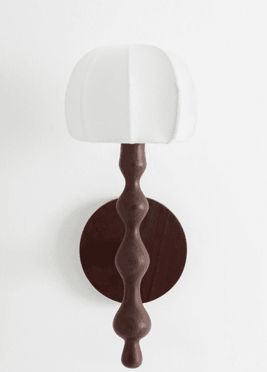 A wall-mounted lighting fixture featuring a circular dark wood backplate and a sinuously turned wooden arm, topped with an off-white, segmented fabric shade. The design is sculptural and organic. — 3D model