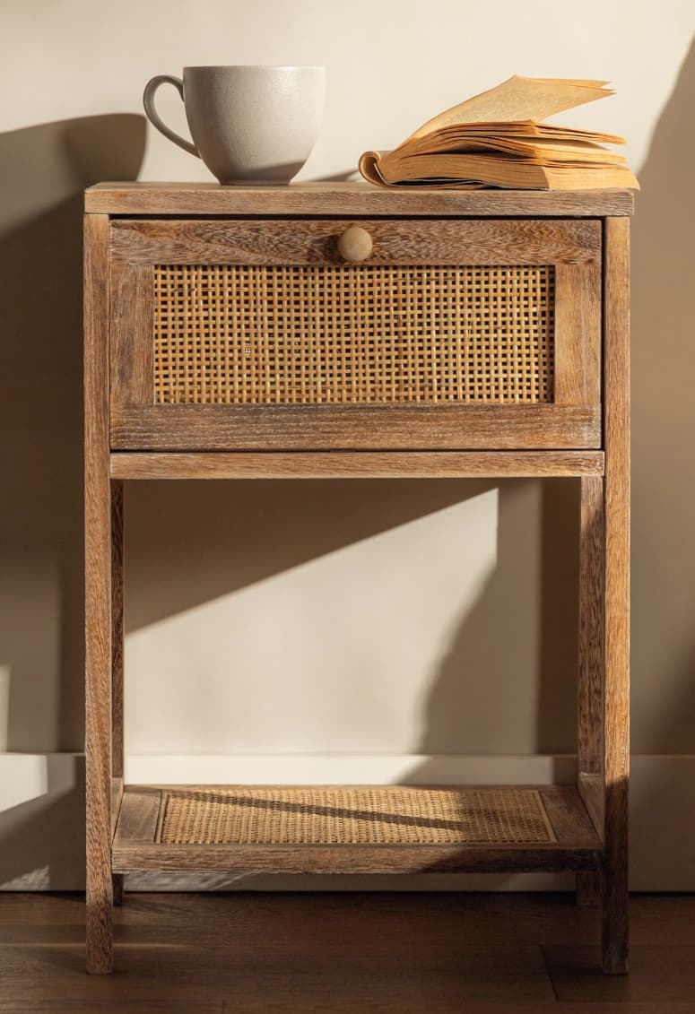 A small rectangular nightstand crafted from light-toned wood, featuring a single top drawer with a woven rattan front and a matching rattan-surfaced open lower shelf. It stands on four straight legs. — 3D model