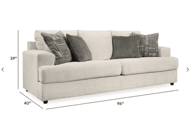 A modern three-seater sofa upholstered in a light beige textured fabric, featuring clean lines, wide block arms, and removable seat and back cushions. It comes with four accent throw pillows in varying patterns and solid gray, complementing its contemporary aesthetic. The sofa sits on discreet, short black feet, giving it a low-profile stance. — 3D model