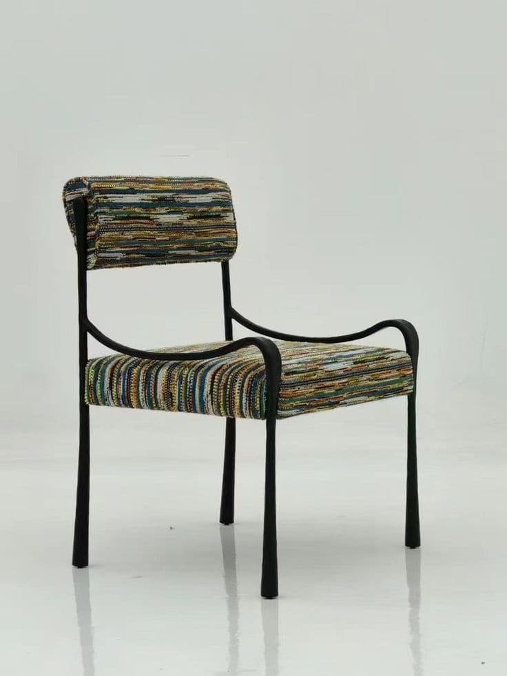 An accent armchair featuring a minimalist black tubular metal frame with a rectangular backrest and seat, both upholstered in a vibrant, multi-colored striped fabric. — 3D model