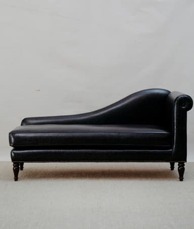 A traditional black leather chaise lounge featuring classic design elements such as a rolled arm, curved backrest, and nailhead trim. — 3D model