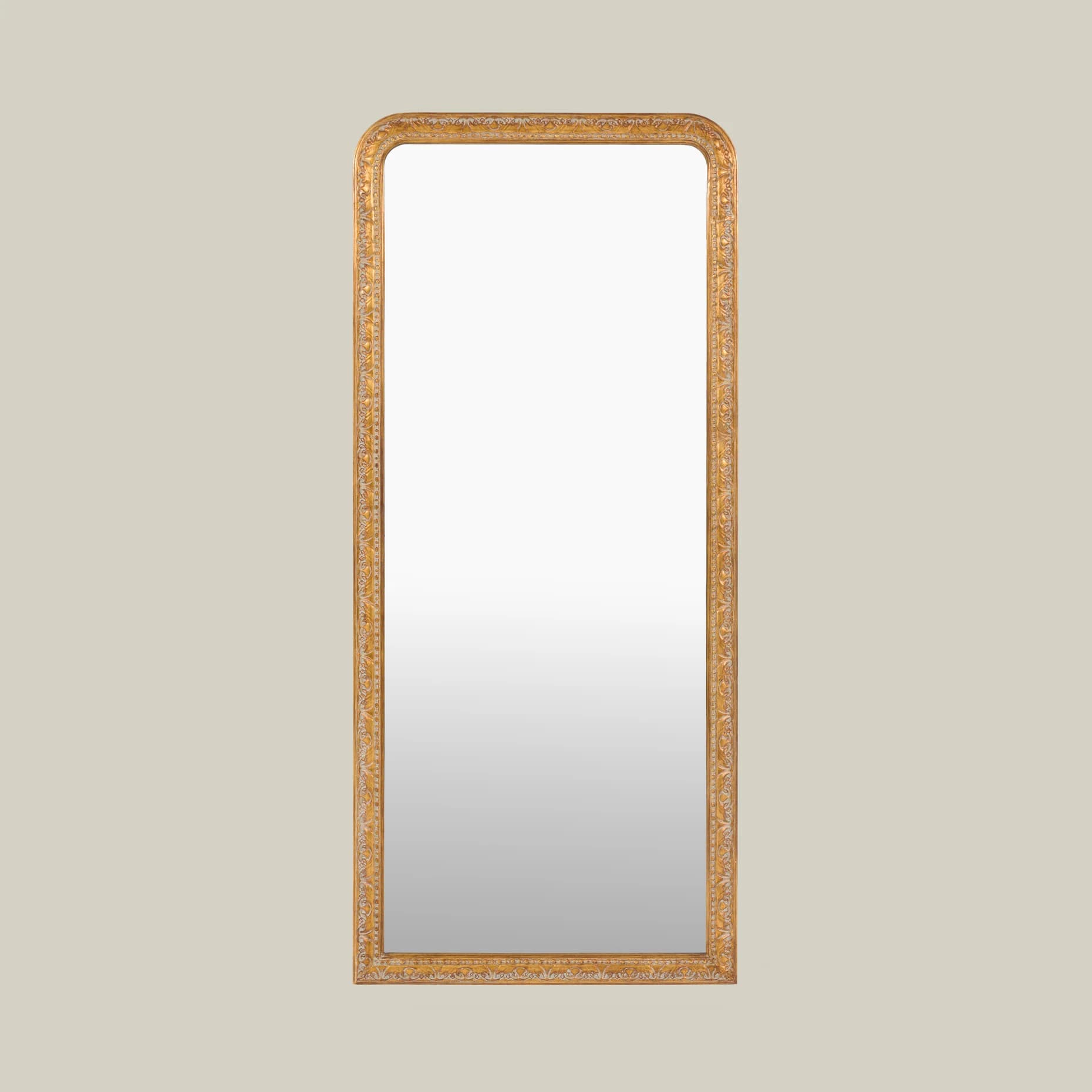 A tall, rectangular wall mirror featuring rounded top corners and an intricately carved, gilded frame. The frame displays elaborate floral and foliate motifs, characteristic of traditional or classical design styles, rendered in an antique gold finish. The mirror surface itself is a standard reflective glass. — 3D model