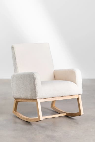 A rocking chair with a plush, textured upholstery and a natural wood frame. The chair features a high back, rounded armrests, and a curved base designed for rocking motion. The wood frame is visible beneath the upholstered seat and back, connecting the seat to the rocking base. — 3D model