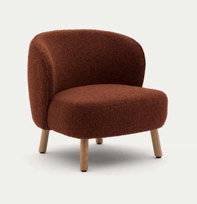 A low-profile, armless lounge chair upholstered in a textured, reddish-brown (burnt orange) boucle fabric. The chair features a compact, rounded silhouette with a gently curved backrest that flows into the deep seat. It is supported by four short, subtly splayed wooden legs. — 3D model