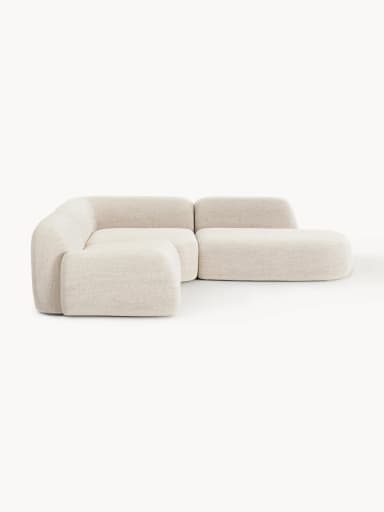 A contemporary modular sectional sofa featuring soft, rounded forms and upholstered in a light-colored, textured fabric. The configuration includes a two-seat section, a corner piece, and an integrated ottoman/chaise extension, creating an L-shaped layout with a low profile. — 3D model
