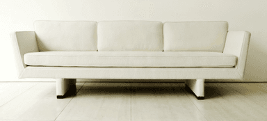 A contemporary three-seater sofa upholstered in an off-white bouclé-like fabric, featuring a single button-tufted seat cushion, three loose back cushions, and integrated wide arms resting on a recessed, block-like base. — 3D model
