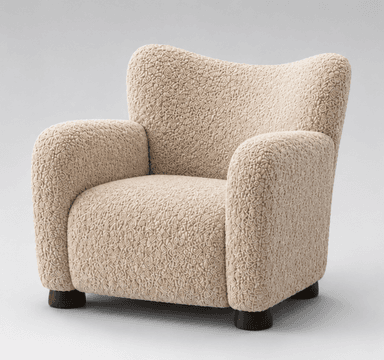 A modern upholstered armchair featuring a distinctive highly textured, beige fabric and a rounded, inviting silhouette, set on small, dark wooden feet. — 3D model