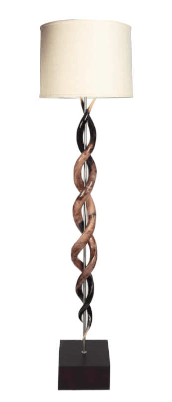A contemporary floor lamp featuring a sculptural, twisted column base composed of alternating dark and light-colored elements that resemble polished horn or resin, intertwined around a central metallic rod. The base rests on a rectangular dark brown plinth. It is topped with a simple, cylindrical off-white fabric drum shade. — 3D model