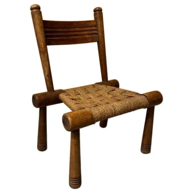 A rustic, low-seated wooden chair featuring a sturdy frame of dark-stained wood and a tightly woven seat made of natural rush or rope. It has a simple backrest composed of two horizontal wooden slats. — 3D model