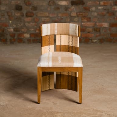 A wooden chair with a curved backrest. The backrest features contrasting wood panels with decorative etched patterns. The seat is upholstered with a fabric that has a striped and patterned design. — 3D model