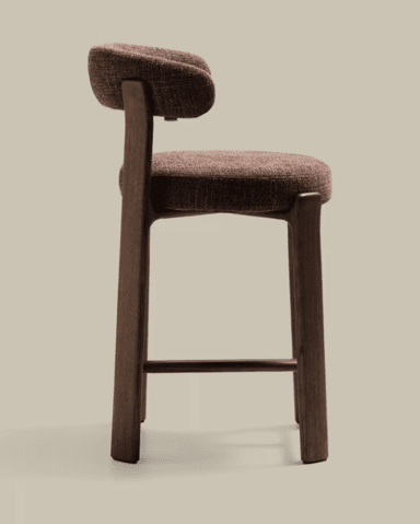 A modern counter stool featuring a dark wood frame and upholstered seat and backrest. The stool has a seat height of 56 cm and an overall height of 90 cm, suitable for counter-height surfaces. The backrest is rounded and upholstered in a textured, reddish-brown fabric, matching the circular seat cushion. The wooden frame consists of four sturdy, slightly tapered legs connected by stretchers on three sides, providing a stable structure and a footrest. — 3D model