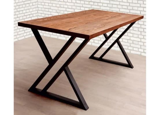 A rectangular table featuring a light to medium brown wood-grain tabletop supported by a distinctive black angular metal base, forming an X-shape on each end. — 3D model
