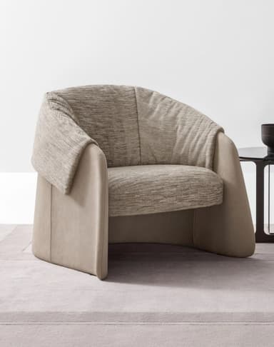 A contemporary lounge chair featuring a two-tone upholstery design, with a smooth, light beige outer shell forming wide, curved armrests and base, and a contrasting textured light brown fabric on the deep seat cushion and draped backrest. The chair has a substantial, low-profile silhouette with soft, rounded lines. — 3D model