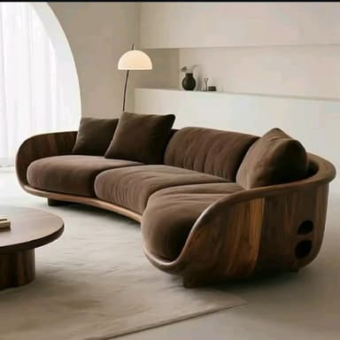 A curved, sectional sofa with a modern design. It features a soft, upholstered finish and appears to be modular, consisting of at least two connected sections. Two accent pillows in a contrasting darker shade are placed on one section. — 3D model