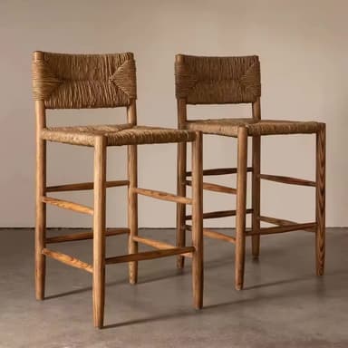 A natural wood bar stool featuring a woven rope seat and backrest, supported by four tapered wooden legs connected by horizontal and diagonal footrests. The construction appears sturdy and the materials suggest a natural, organic aesthetic. — 3D model