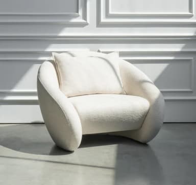 A contemporary lounge chair with a rounded, organic silhouette, fully upholstered in a textured, off-white fabric, and featuring a loose back cushion. — 3D model