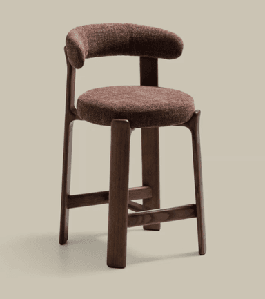A modern counter stool featuring a dark wood frame and upholstered seat and backrest. The stool has a seat height of 56 cm and an overall height of 90 cm, suitable for counter-height surfaces. The backrest is rounded and upholstered in a textured, reddish-brown fabric, matching the circular seat cushion. The wooden frame consists of four sturdy, slightly tapered legs connected by stretchers on three sides, providing a stable structure and a footrest. — 3D model