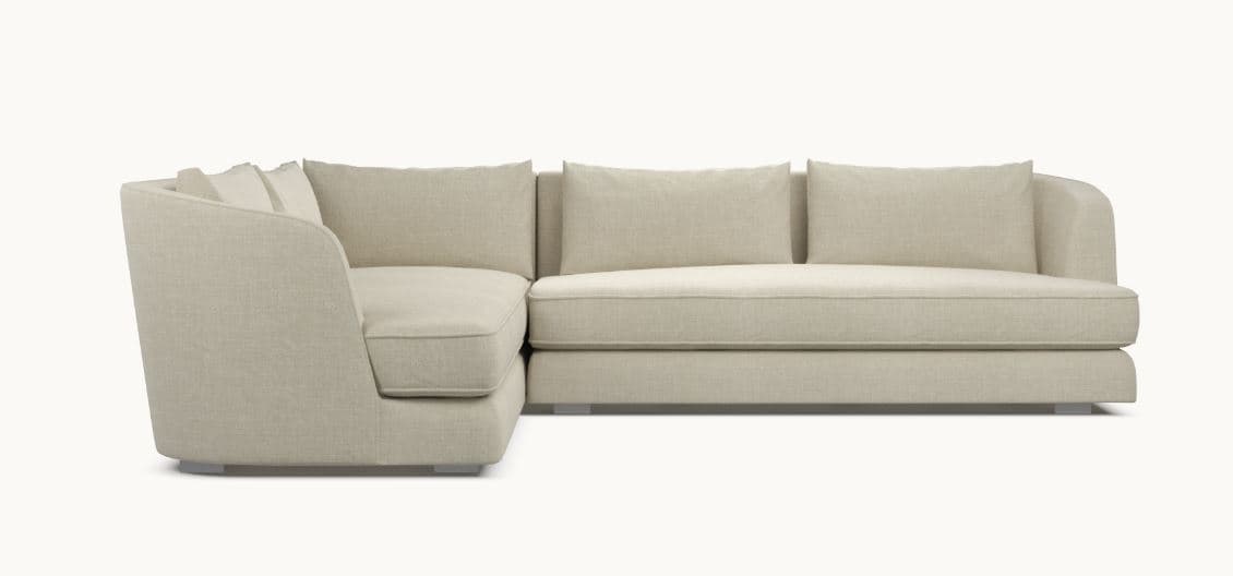 A modern sectional sofa with a light beige fabric upholstery. The sofa features a chaise lounge on the left and a sofa section on the right, with loose back cushions. The design is minimalist with clean lines and a low profile, supported by subtle metallic legs. — 3D model