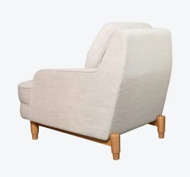 A upholstered armchair with a tufted back cushion. The armchair features a rounded silhouette with padded arms and a fixed seat cushion. It is supported by four tapered wooden legs. — 3D model