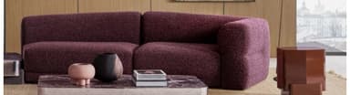 A contemporary modular sectional sofa featuring two interconnected units, one of which forms a chaise lounge, upholstered in a textured plum-colored fabric with a low-profile design. — 3D model