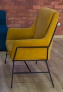 An upholstered armchair featuring a vibrant mustard yellow fabric and a sleek, minimalist black metal frame. — 3D model