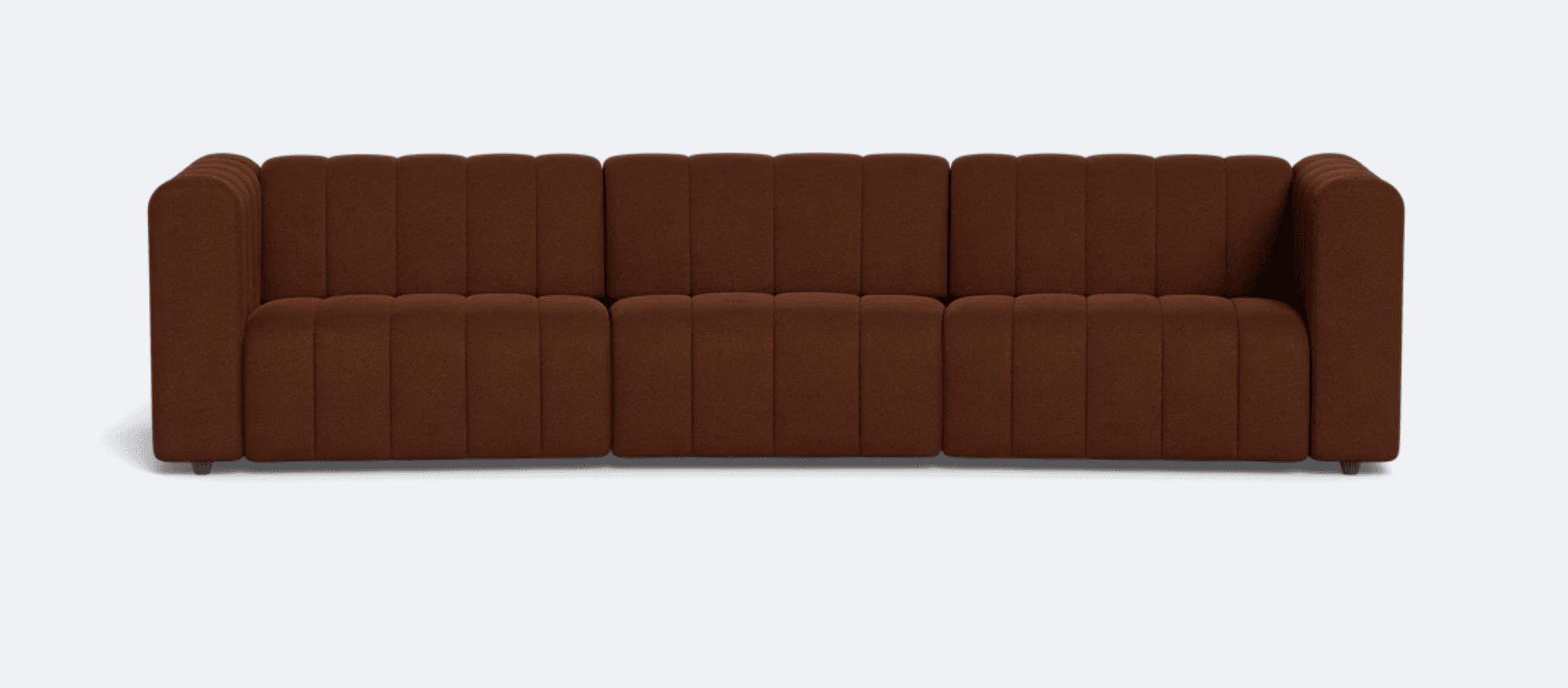 A three-seater sofa upholstered in a textured brown fabric. The sofa features a channel-tufted design on the back cushions and seat, creating vertical pleats across its surface. It has a low-profile frame with subtly rounded corners and short, dark legs. The overall aesthetic is modern and inviting. — 3D model
