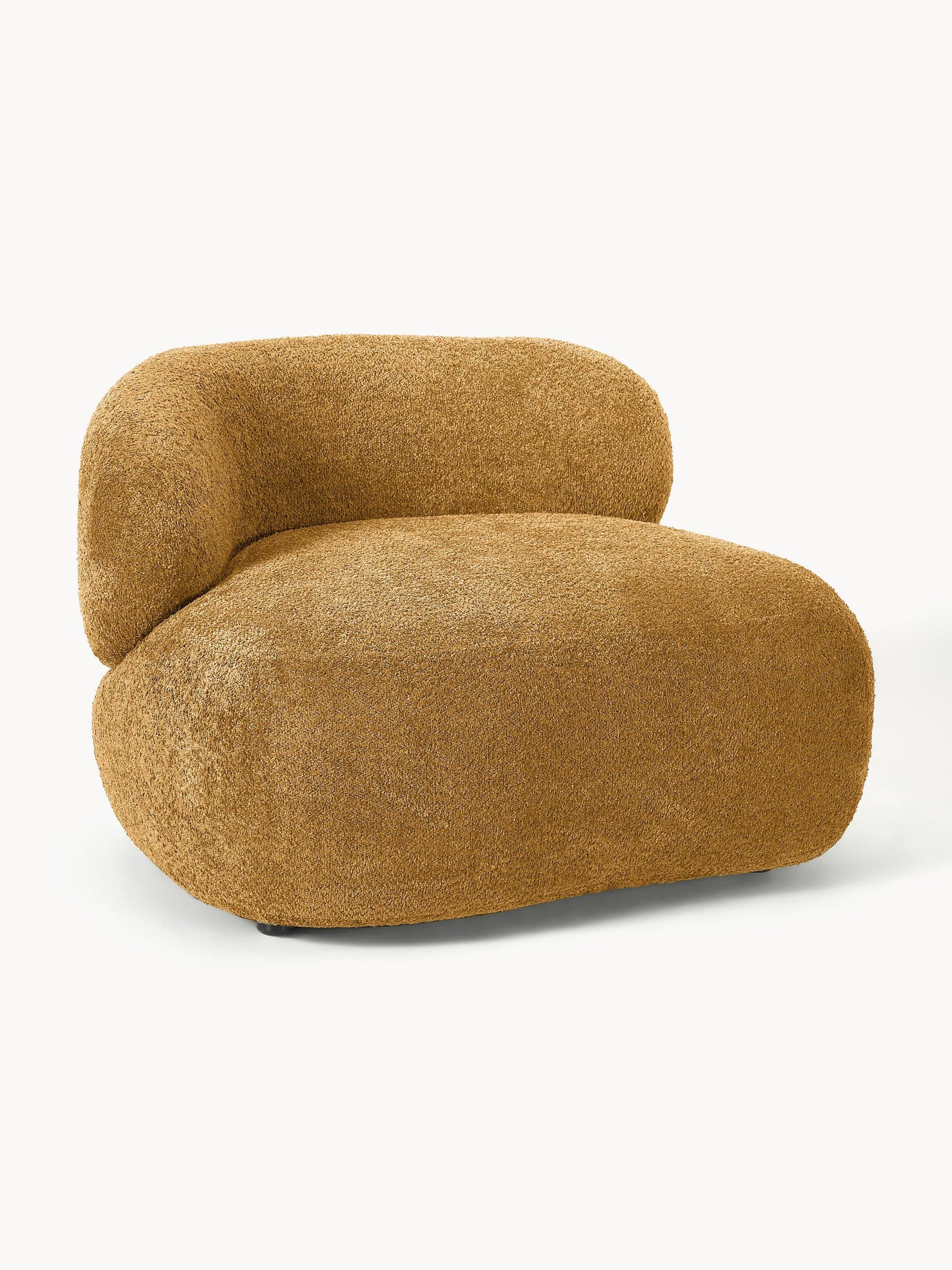 A single-seater lounge chair featuring a distinctive curved and organic form, upholstered entirely in a textured, golden-brown boucle fabric. The design is armless with a low, enveloping backrest that gently curves around the side, suggesting a comfortable and modern aesthetic. The chair appears to be fully upholstered, with no visible legs beyond small, discrete glides at the base. — 3D model