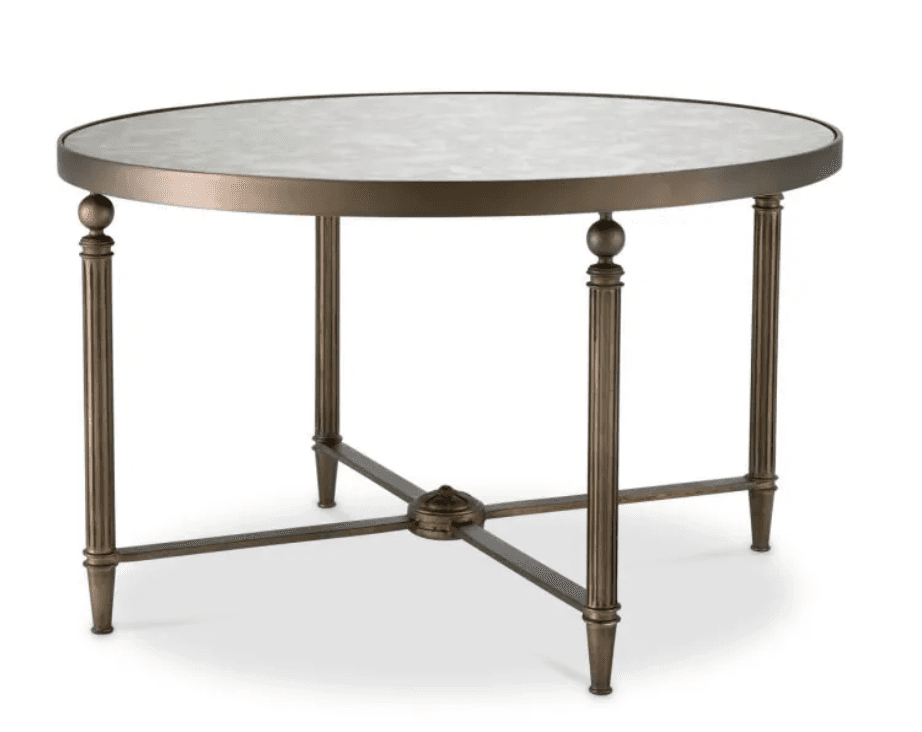 A round coffee table featuring a metallic frame with an antiqued bronze or brass finish and a distressed mirrored glass top. The four columnar legs are fluted and include spherical accents, connected by an X-shaped stretcher base with a central finial. — 3D model