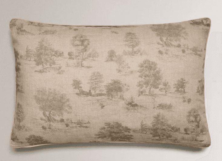 A rectangular cushion with a toile de Jouy-style print depicting a pastoral landscape with trees and figures. The fabric appears to be a natural fiber, and the edges are piped. — 3D model