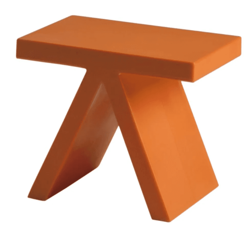 A modern, abstract-designed stool with a T-shaped base and a rectangular seat. The structure appears to be made from a solid, molded material with smooth, clean lines and a matte finish. The two vertical-leaning supports of the base are connected by a horizontal element, creating an open, angular form. — 3D model