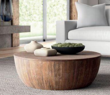 A low-profile, circular coffee table constructed entirely from natural wood slats. The tabletop is flat and composed of horizontal slats, while the body forms a curved, drum-like shape from vertical slats. The wood displays a light to medium brown tone with visible grain and knots. — 3D model