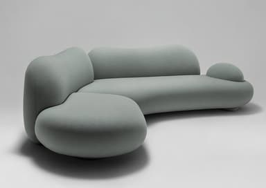 A contemporary, L-shaped sectional sofa featuring organic, rounded, and biomorphic forms, upholstered in a light green, textured fabric. Its design emphasizes soft lines and a cohesive, flowing silhouette. — 3D model