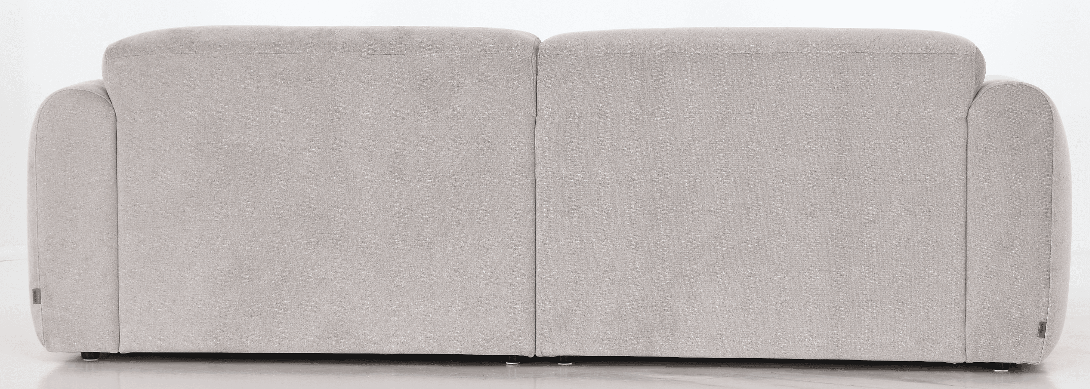 A sofa viewed from the back, featuring a neutral-toned fabric upholstery. The sofa appears to have a modern design with rounded armrests visible on the sides. The back is divided into two distinct cushioned sections, separated by a vertical seam. Small, dark-colored feet are visible at the base. A small, light-colored tag with an emblem is attached to the lower corner of the right side. — 3D model
