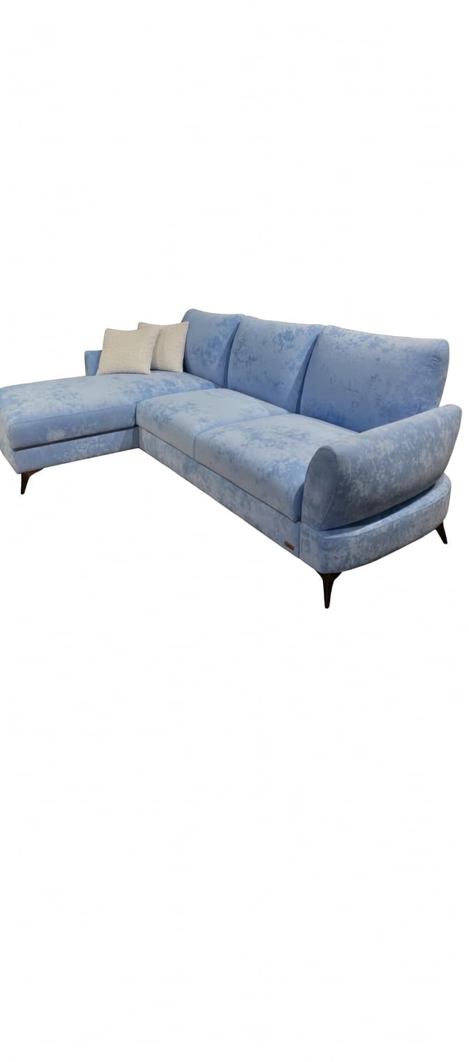 A light blue sectional sofa with a chaise lounge extension. The sofa features three back cushions and two decorative throw pillows on the chaise. The upholstery has a textured, slightly marbled appearance. The sofa rests on slender, angled legs. — 3D model