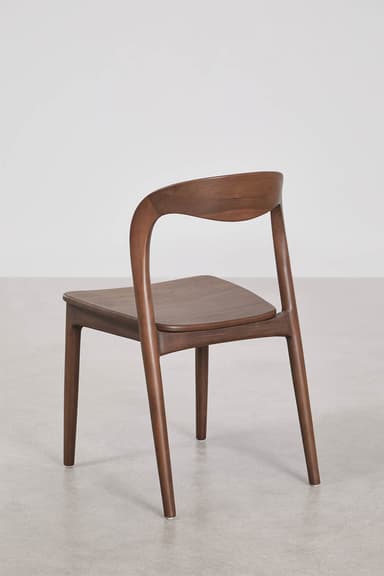A contemporary dining chair crafted from dark wood, featuring a gracefully curved backrest that seamlessly transitions into the rear legs. The seat is flat and slightly rounded at the edges, supported by four tapered legs. The overall design emphasizes smooth lines and a minimalist aesthetic. — 3D model