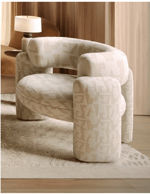 A modern upholstered armchair featuring a curved backrest and rounded, chunky armrests and legs, all covered in a cream-colored fabric with a subtle, geometric, repeating pattern. — 3D model